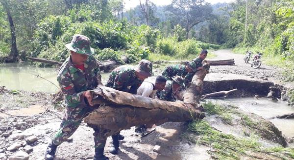 Cuaca Buruk di Pemukiman Suku Mausu Ane, Prajurit TNI Sigap Singkirkan Pohon Tumbang 
