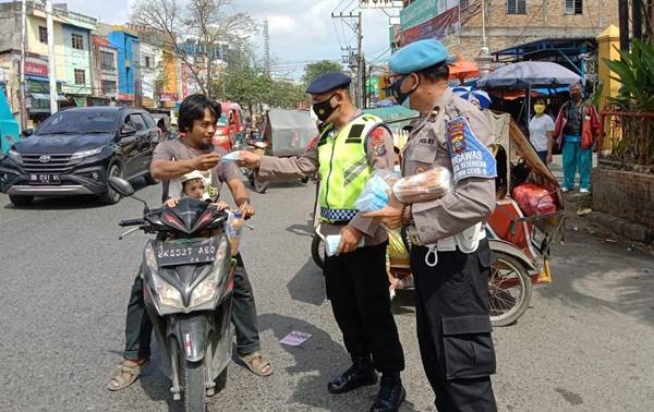 Brimob Polda Sumut Bagikan Masker di Simpang Limun