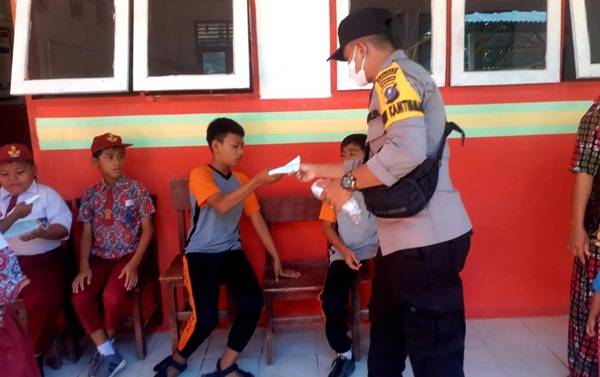 Briptu Juno Bagikan Masker Kepada Anak SD