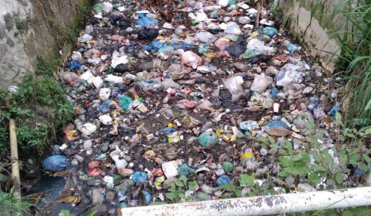 Sampah Menumpuk di Saluran Air Perbatasan Kelurahan Rengas Pulau dengan Terjun