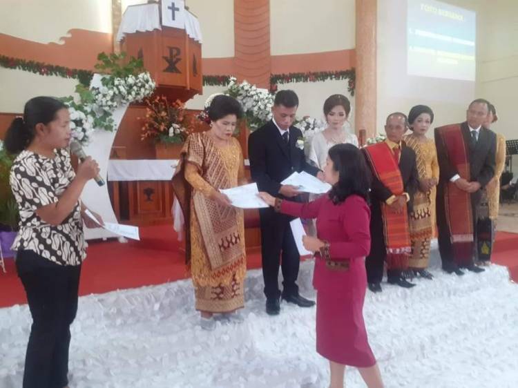Disdukcapil Serahkan Administrasi Kependudukan Kepada Pengantin Pasangan Baru di HKBP Pargodungan Doloksanggul