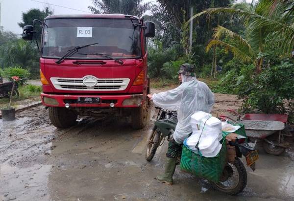 Terjang Hujan dan Lumpur, Praka HF Manalu Antarkan Nasi Buat Satgas dan Warga di Lokasi TMMD