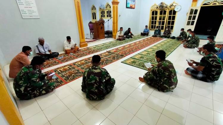 Anggota Satgas TMMD melaksanakan Yasinan bersama warga