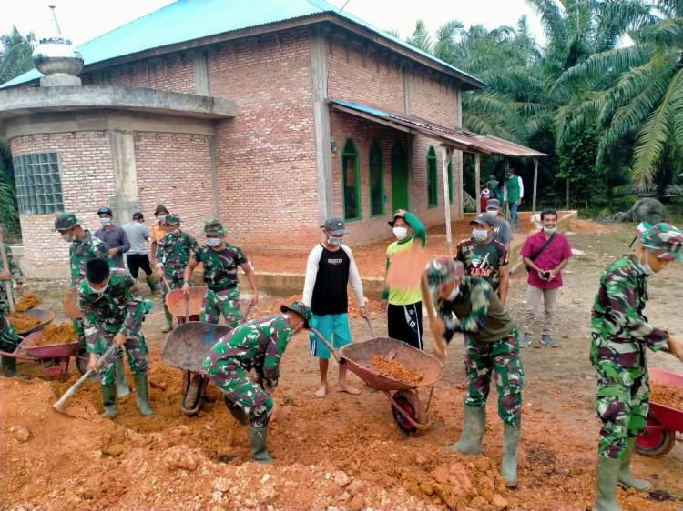 Isi waktu luang, anggota Satgas TMMD bantu penimbunan halaman Masjid.