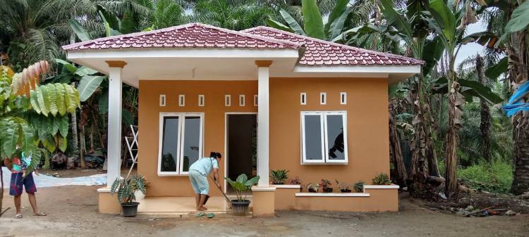 Senang rumahnya selesai dibangun, Bu Dede bantu anggota Satgas TMMD bersihkan rumah.