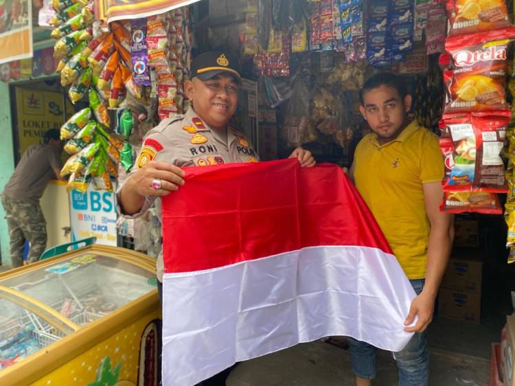 Kapolsek Muara Dua Bagikan Bendera Merah Putih Kepada Masyarakat