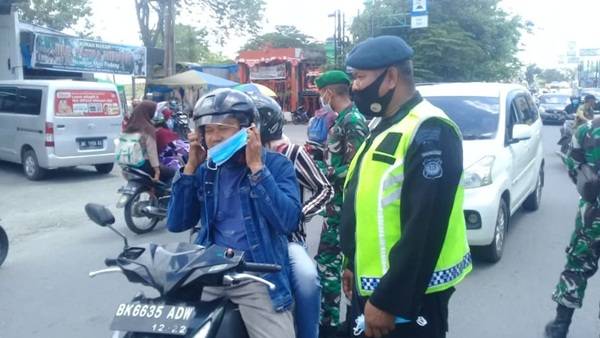 Brimob Polda Sumut  Bagikan Masker Kepada Masyarakat di Sekitaran Denai