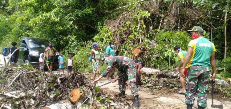 Prajurit Satgas Yonif 413 Kostrad Bersama Warga Bersihkan Pohon Tumbang di Jalan Poros Jayapura