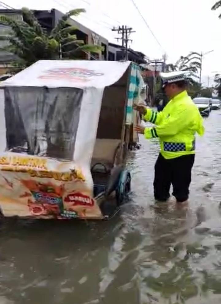 Kanit Lantas Polsek Medan Sunggal Dorong Kendaraan Mogok karena Banjir