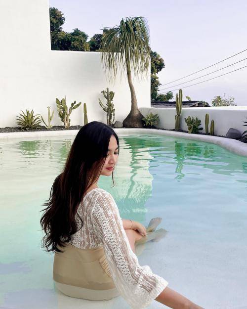 Potret Dokter Lily Saat Duduk Santai di pinggir Kolam Renang, sambil Menoleh