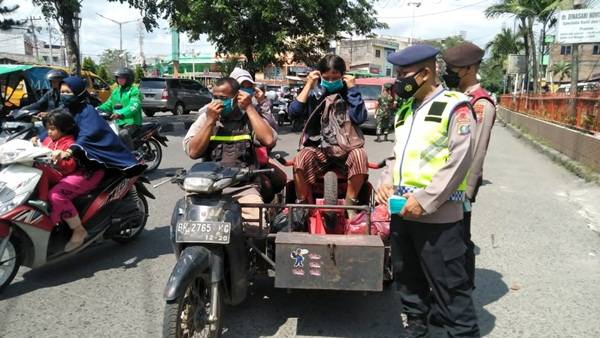 Brimob Polda Sumut Laksanakan Ops Yustisi dan Bagikan Masker di Simpang Limun