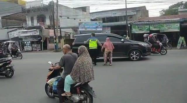 Personel Pos Pam 12 Citra Garden  Bantu Ibu Lansia Menyeberangkan ke Jalan