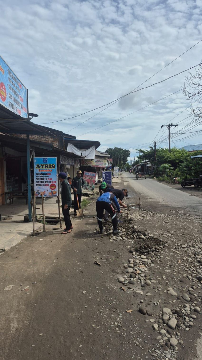 Pemdes Bandar Setia Ajak Warga Gotong Royong Timbun Jalan Berlubang